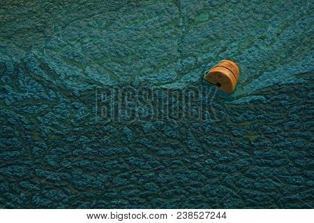 Orange Buoy On The Waves As A Symbol Of Help And Hope. Green Background. Sludge Texture. Abstract. N