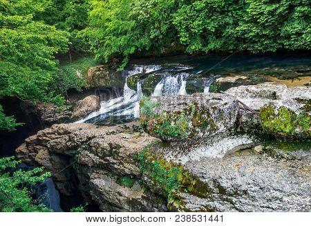 Amazing Forest Waterfall Flowing Into The Cold Mountain River With Large Stones. Martvili Canyon.
