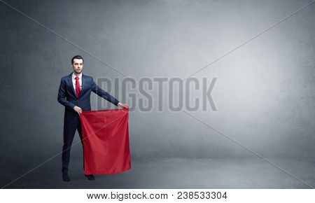 Businessman standing with red toreador cloth in his hand in an empty room