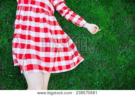 Woman Lay On Green Grass In Red Dress. Overhead View