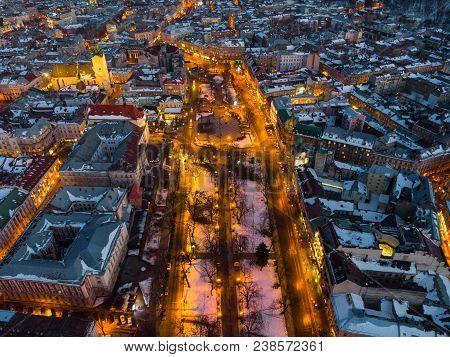 Aerial View Of City In Night Time. Streets In Car Lights.