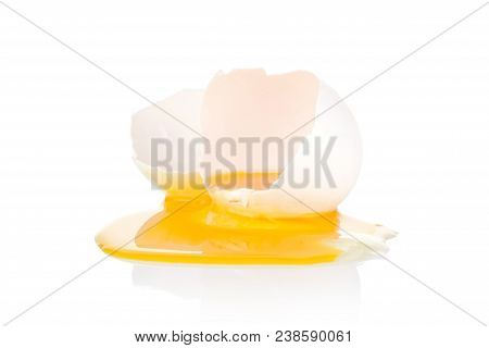 One Cracked White Chicken Egg With Dripping Out Yolk Isolated On White Background