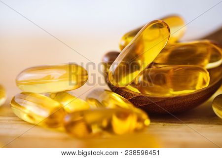 Close Up Vitamin D And Omega 3 Fish Oil Capsules Supplement On Wooden Plate For Good Brain , Heart A