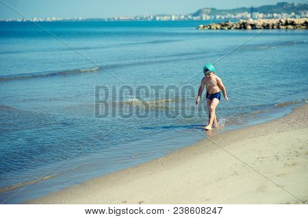 Littl Boy Is Running Along The Beach Playing And Splashing In Water Of Adriatic Sea In Durres, Alban