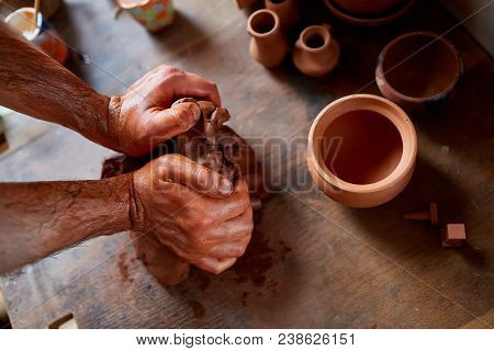 Hands Of Male Potter Molding A Clay In Pottery Workshop, Close-up, Selective Focus. Creative Work Pr