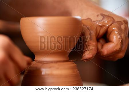 Close-up Hands Of A Male Potter In Plaid Shirt And Dirty Apron Who Molds Bowl From Clay, Selective F