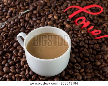 Cup Of Coffee With Milk On Background Of Coffee Beans
