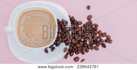 Grains Of Roasted Coffee Scattered From A Cup On A Pink Background, Copy Space. Top View.