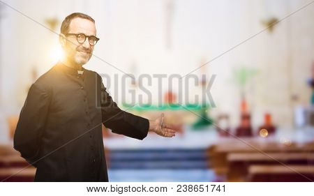 Priest religion man confident and happy with a big natural smile inviting to enter at church