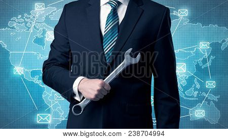 Businessman holding tool with global map graphic on the background