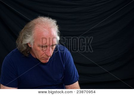 Hombre mirando hacia abajo y con los hombros caídos