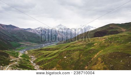 Beautiful View Of The Snow-covered And Vegetated Caucasus Mountains