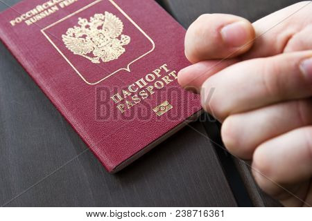 Men's Hand Shows The Fico On Passport Backgound. Symbol Of Sanctions. Negative Concept. Closeup