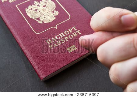 Hand Showing The Fig Sign, On Red Russain Passport Background.
