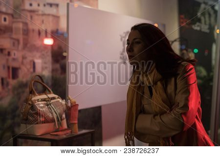 Girl Brunette Near In The Shopwindow On The Night City Street In A Cold Time