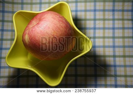 An Apple In A Yellow  Plate  With The Shape Of Star