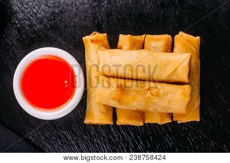Lumpias With Sweet Sauce On A Black Background