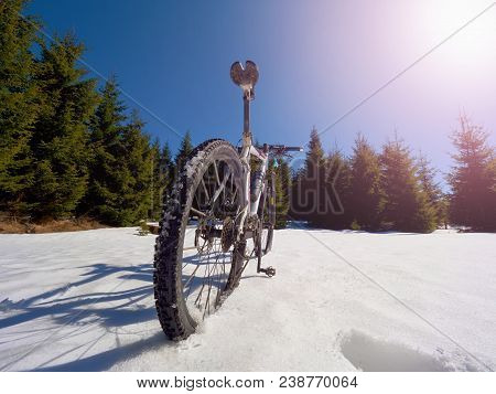 Wide View Photo Of Mountain Bike In Deep Snow. Winter Mountains With Road Lost Under Snow.