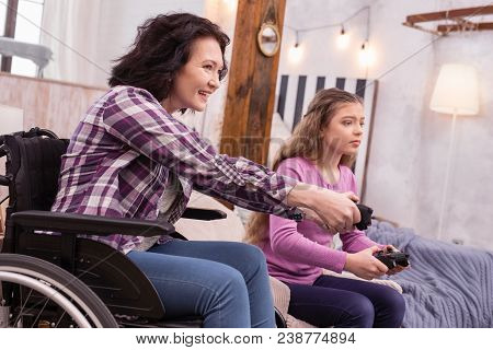 Genuine Fun. Merry Incapacitated Woman And Girl Using Controller While Playing Game