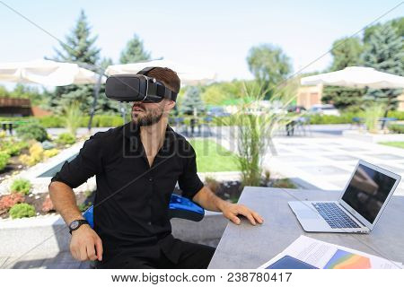 European Businessman Working With Papers And Laptop, Enjoying Virtual Reality Glasses In Open Air . 