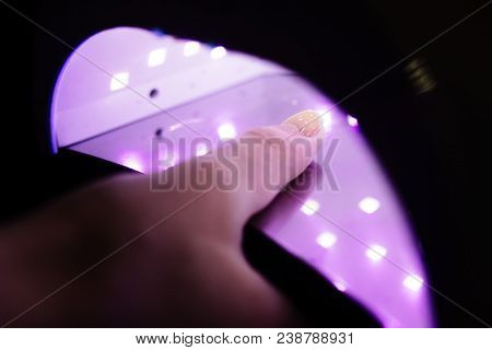Uv Lamp Gel Polish Manicure Process In A Beauty Salon. Salon Procedure. The Master Coats The Client'