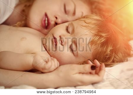 Closeup Of Young Loving Mother With Light Blonde Curly Hair Holding Small Tiny Cute Lovely Baby Boy 