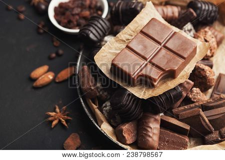 Assortment Of Candies And Milk Chocolate Bar With Piece Bitten Off In Vintage Platter. Various Sweet