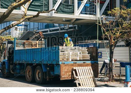 Portugal, Lisbon 29 April 2018: Builder Works At Construction Site Or Building Site. Builder Unloads