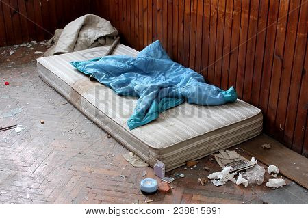 Abandoned Room With Old Mattress, Cover, Stick, Hand Lotion, Open Condom Wrappers, Tissues, Old News