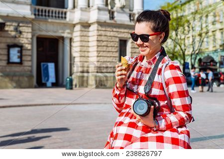 Tourist Woman With Photo Camera And Ice Cream In The Middle Of European City