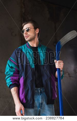 Handsome Young Man In Vintage Windcheater With Hockey Stick