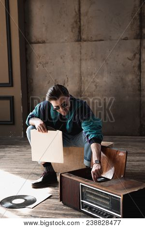 Smiling Young Man In Vintage Windcheater With Vinyl Record Player