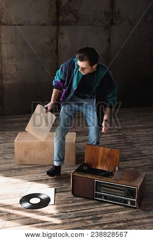 Nostalgic Man In Vintage Windcheater With Vinyl Record Player