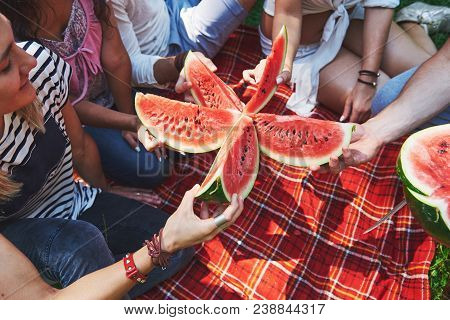 Cheerful Friends Enjoying Watermelon On Picnic On Sunny Summer Day.
