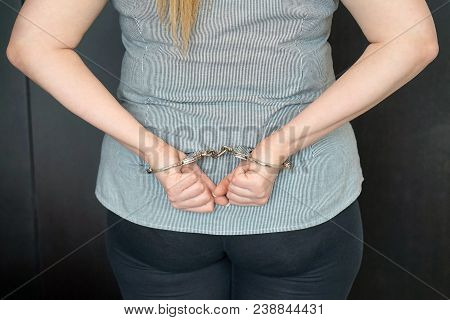 Close-up. Arrested Woman Handcuffed Hands At The Back. Prisoner Or Arrested Terrorist, Hacker, Bribe