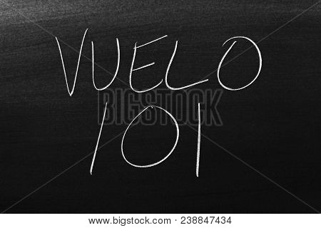 The Words Vuelo 101 On A Blackboard In Chalk.  Translation: Flight 101