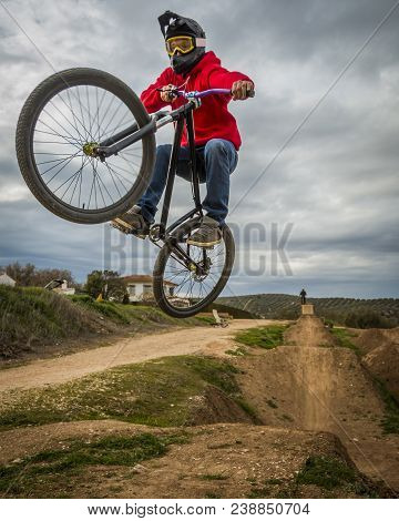 Sportsman Performing Trick And Flying On A Bike In Nature On Dirtjump Circuit