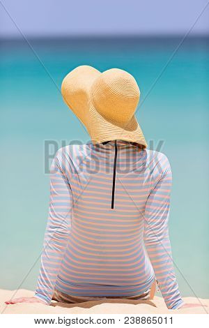 Back View Of Woman In Sunhat And Rashguard Enjoying Summer Beach Vacation, Sun Protection Concept