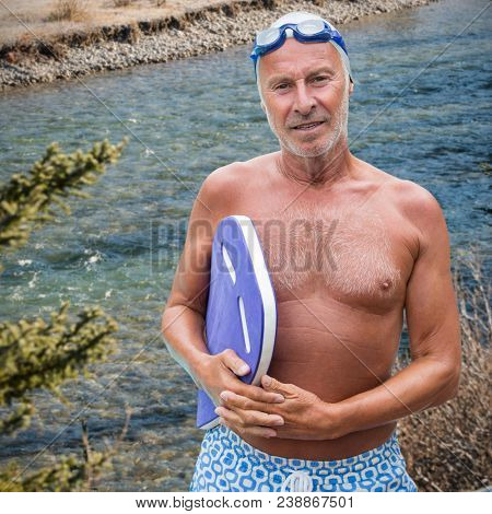 Composite image of portrait of senior male swimmer with swimming float