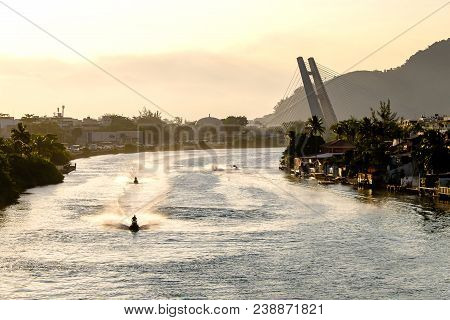 Marapendi Lagoon Seen From Above With Houses On The Hill During Sunset, Golden Light. Jet Skis Are R