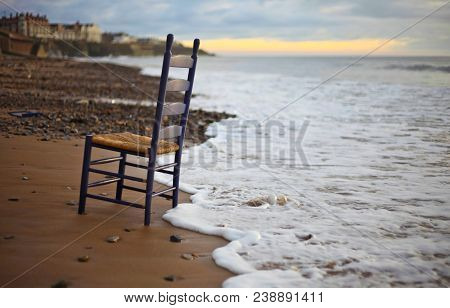 Black Wooden Armless Chair Near Sea At Daytime
