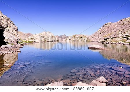 Landscape Photo Of Body Of Water Near The Mountain During Daytime. Montagnette Lake.