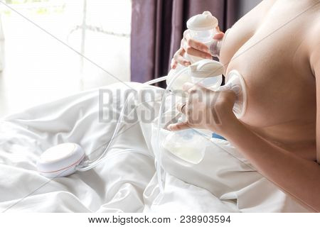Happy And Young Asian Mother Is Pumping Breast Milk For Newborn Baby Feeding And Storage In Refriger
