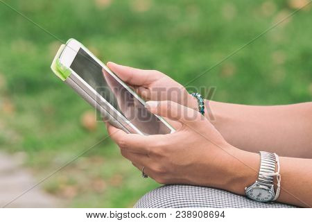 Detail Of A Woman Using Tablet In The Park.