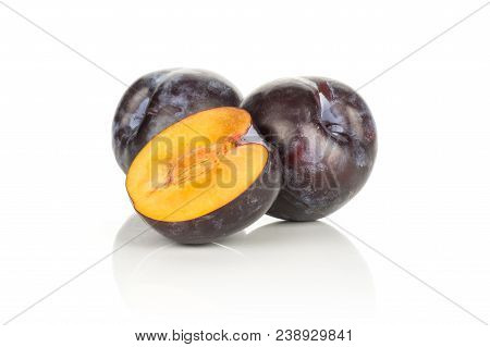 Two Red Blue Plums And One Sliced Half Isolated On White Background