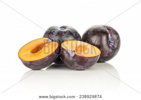 Two Red Blue Plums With Two Sliced Halves Isolated On White Background