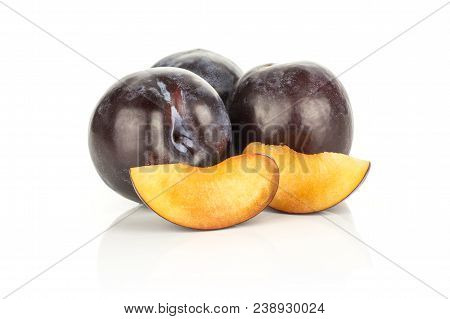 Three Red Blue Plums And Two Slices Isolated On White Background