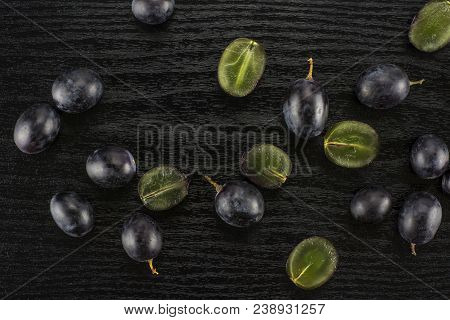 Black Grape Berries (autumn Royal Variety) Table Top Isolated On Black Wood Background Some Sliced