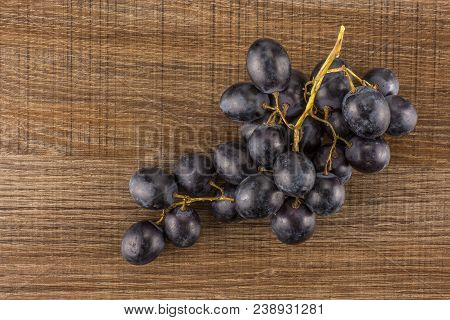Black Grape Cluster (autumn Royal Variety) Table Top Isolated On Brown Wood Background