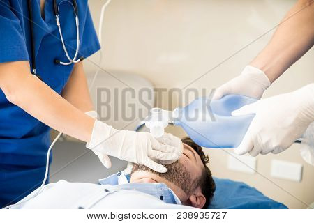 Close Up Of Doctors Hands Using An Ambu Bag For Resuscitating An Unconscious Patient In Emergency Ro